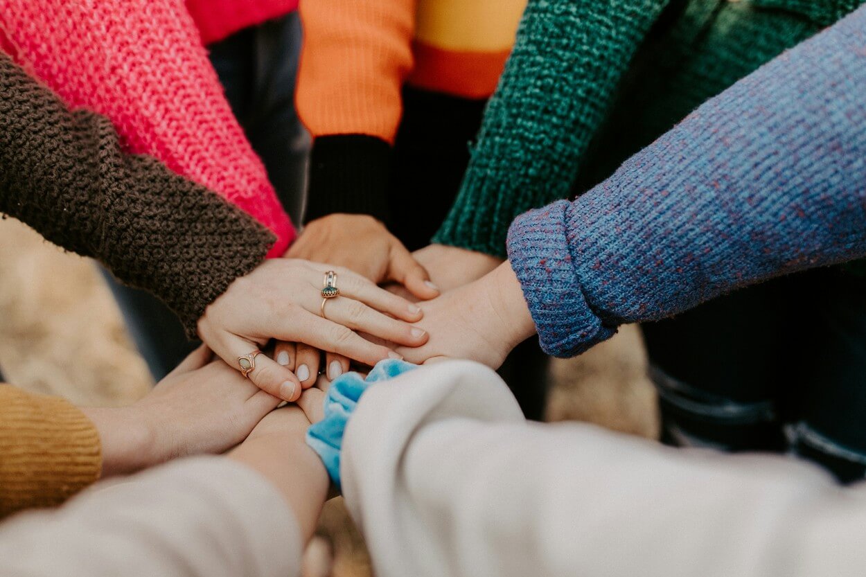 Mains jointes symbolisant la collaboration et l'entraide au sein d'une communauté professionnelle